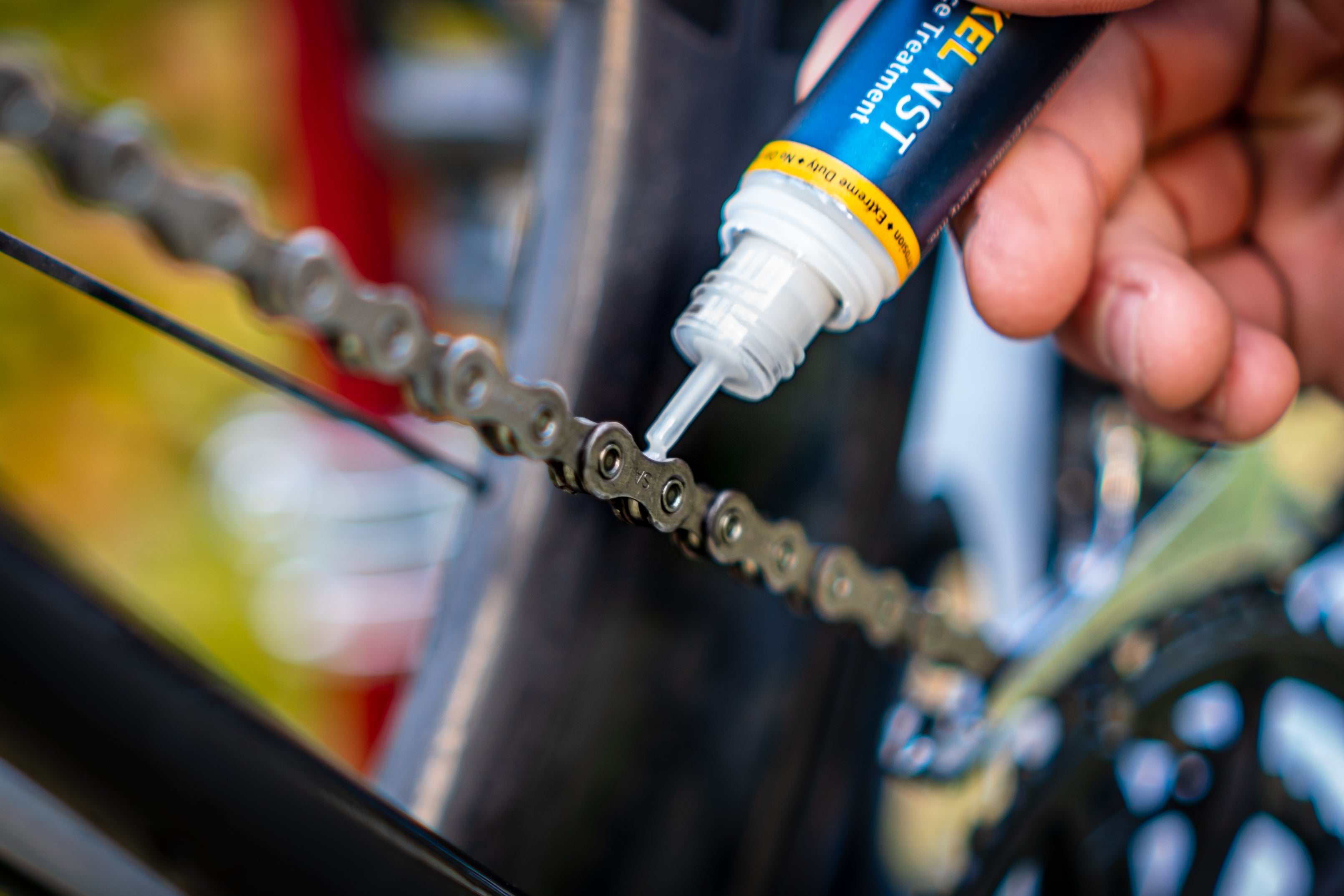 Cyclist applying Tactikel NST to bicycle chain.